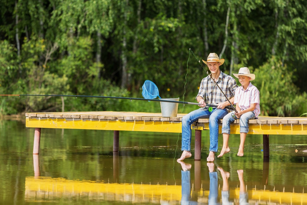 Father and son sitting on bridge and fishing.jpeg