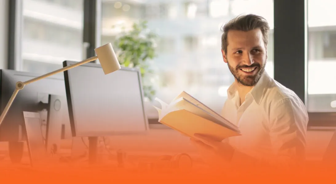 man-reading-book-at-desk-office